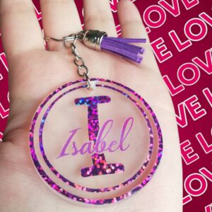 LLAVERO REDONDO CON INICIAL Y NOMBRE EN MORADO HOLOGRAFICO